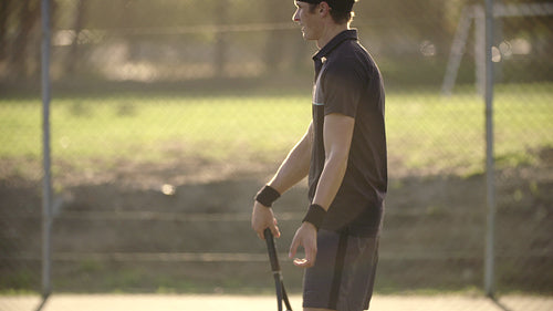 Tennis player walking on the hard court