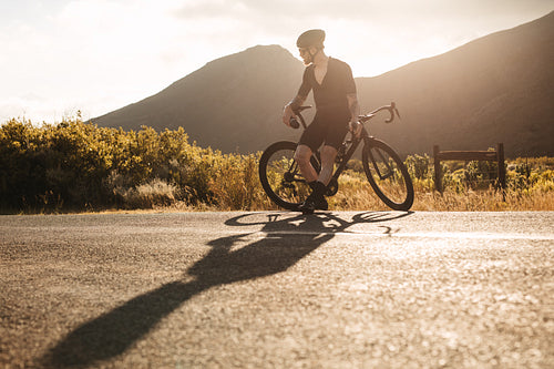 Cyclist taking break on country highway