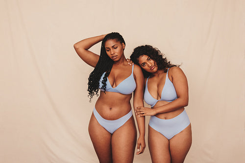 Two young women wearing blue underwear in a studio