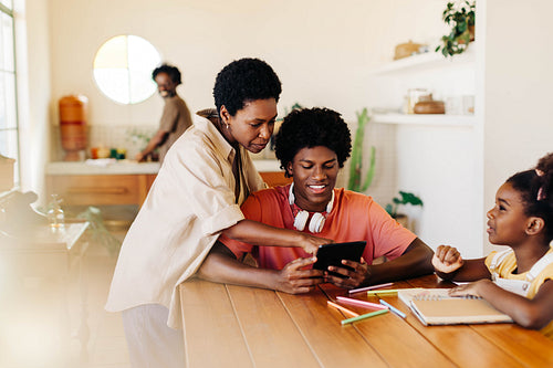 Mother and siblings engaged in educational activities at home