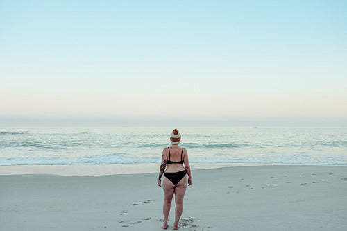 Rearview of a winter bather standing at the beach in swimwear