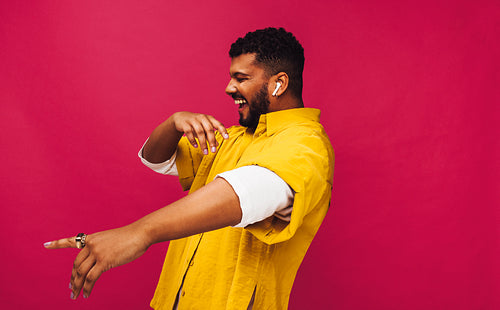 Smiling young man dancing to his favourite music