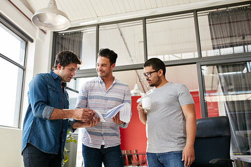 Creative team discussing paperwork in the office