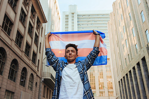 Transman raising the transgender flag in the city