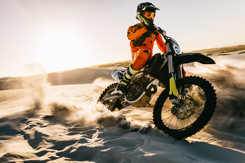 Biker riding fast on dunes