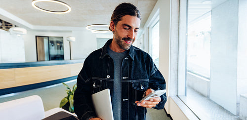 Man typing on his phone in the office