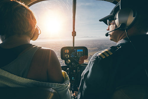 Man flying a helicopter with his copilot