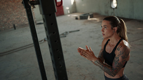 Fit woman doing pull ups exercise in gym