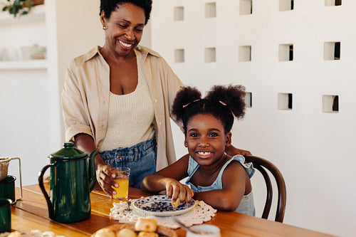 Happy mother and daughter enjoying quality time at home with a delicious morning meal