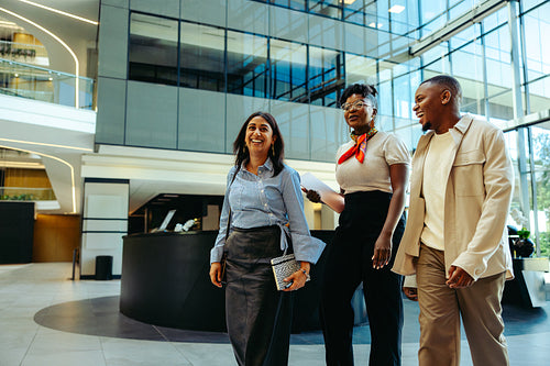 Colleagues walking and discussing business strategies in a contemporary office lobby