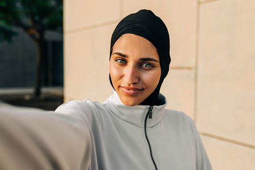 Sporty Muslim woman taking a selfie outdoors