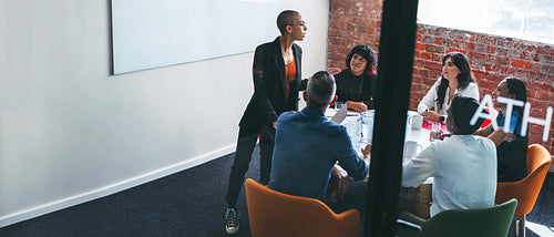 Young businesswoman giving a presentation to her colleagues in a