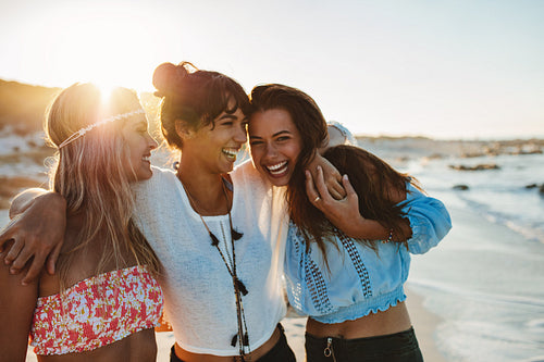 Young female friends walking on the sea shore