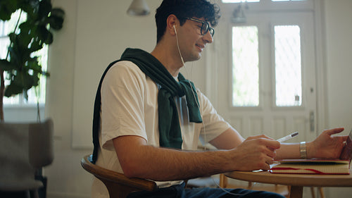 Explaining man speaks on a laptop video call at a workspace desk