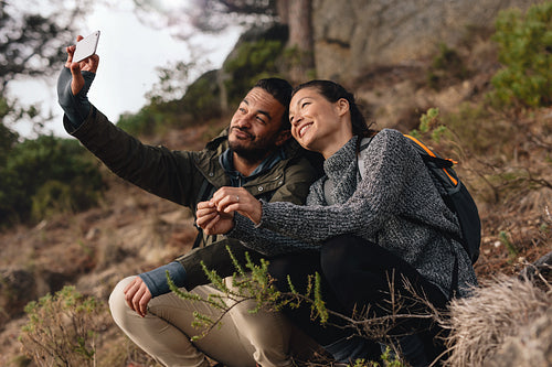Young couple out on hike in mountains taking selfie