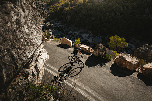 Cyclist riding bicycle on mountain road