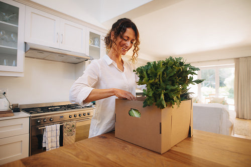 Smiling woman checking the fresh vegetables and fruits