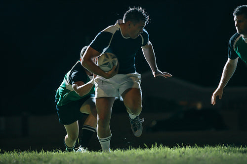 Flanker with ball tackling during game