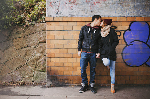 Affectionate teenage couple kissing on street