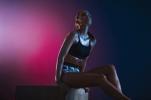 Woman resting on a box after her workout