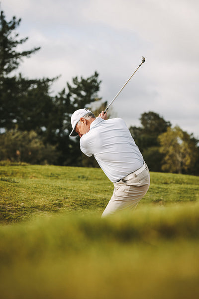 Professional senior golfer making a shot from sand bunker