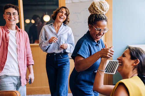 Group of coworkers enjoying a lively moment in an office setting