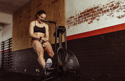Woman doing cardio exercise on bike at gym
