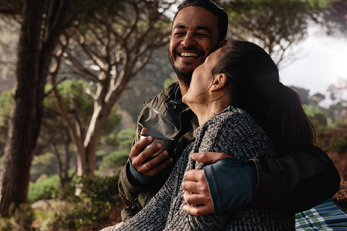 Happy couple camping in forest and having coffee