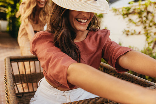 Playful female friends having fun with a trolley cart