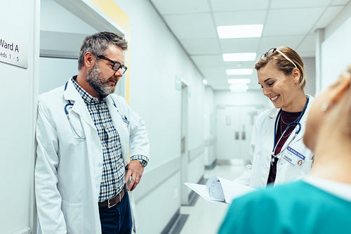 Doctor with colleagues standing in hospital hallway