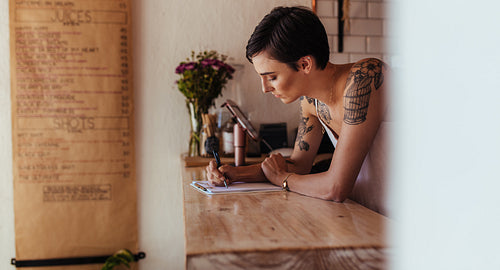 Woman entrepreneur standing at the counter of her cafe