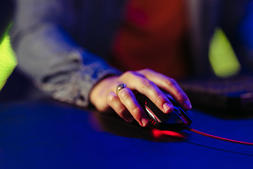 Gamer's hand navigating a mouse on a gaming computer