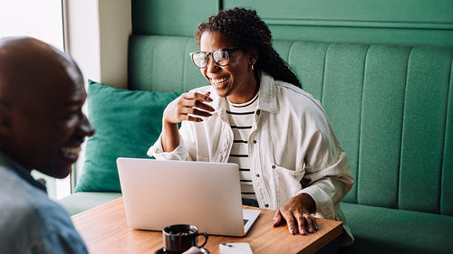 Happy black couple enjoying a fun conversation at a cafe
