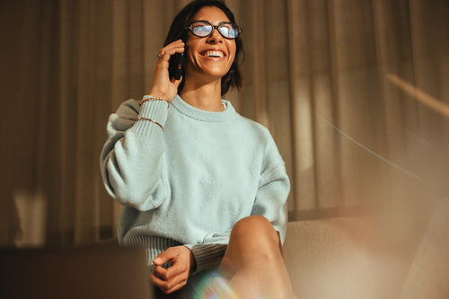 Smiling businesswoman talks on the phone at home in a cozy setting
