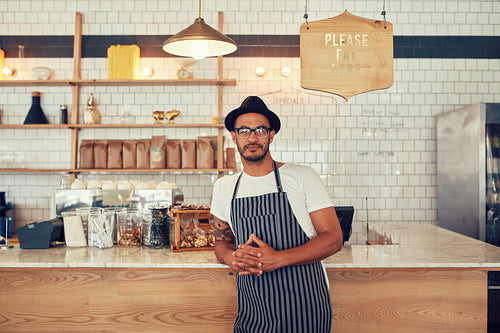 Young coffee shop owner standing at the counter