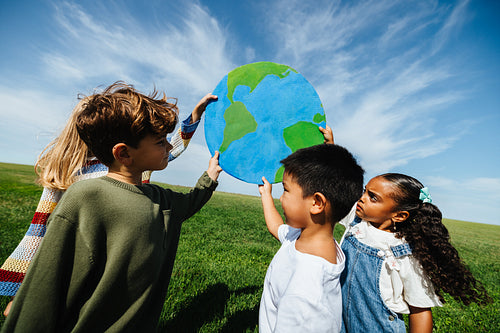 Kids holding globe to promote environmental awareness