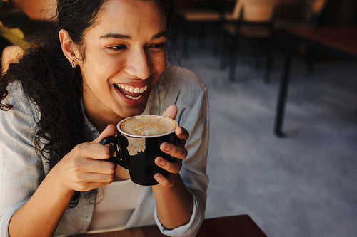 Woman having coffee and smiling in a cafe