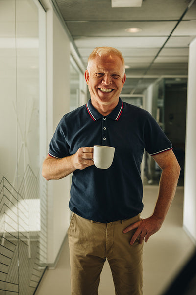 Happy senior businessman having coffee