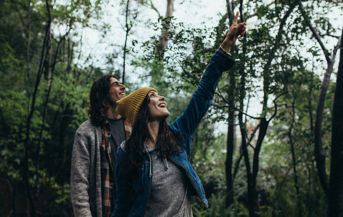 Young couple looking at something interesting in the forest
