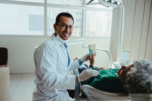 Friendly dentist guidance follows treatment for a senior patient in the dental clinic