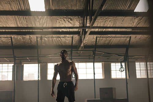 Strong young man with muscular body in gym