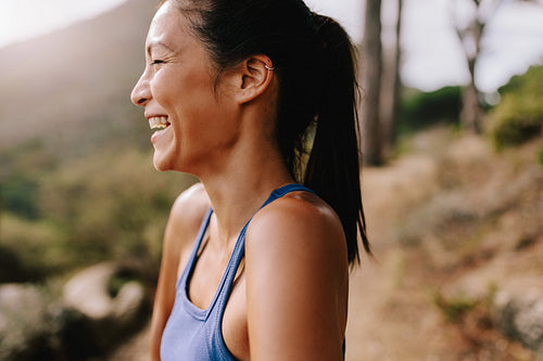 Smiling female runner in sportswear in morning