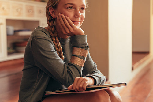 Thoughtful little girl with storybook