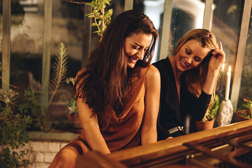Best friends having fun playing the piano in a hotel
