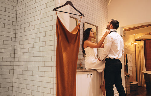 Caring wife helping her husband get dressed