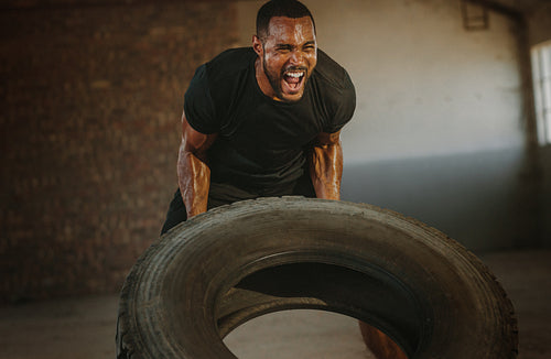 Strong man doing heavy tire flip exercise