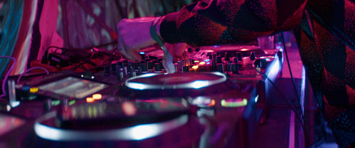 EDM DJ playing music live at a festival- focus on turntables