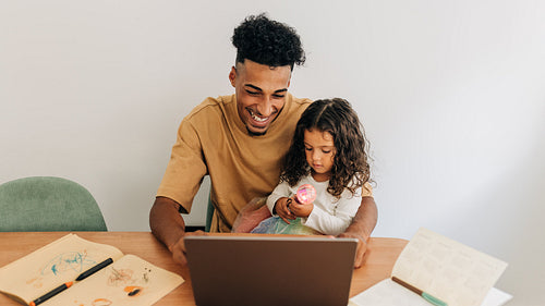 Happy single father sitting in an online class with his daughter