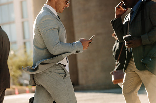 People busy using mobile phone while walking on street to office