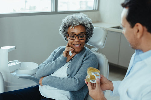 Senior patient dental consultation with dentist in a modern clinic office